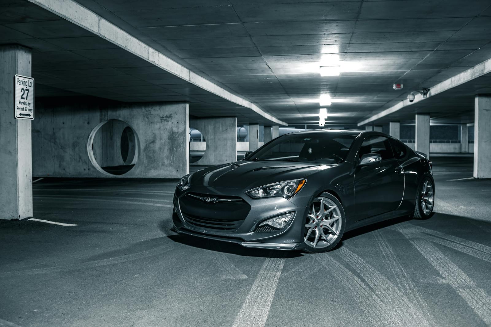 Selective color of gray luxury sports car parked on floor in center of car park